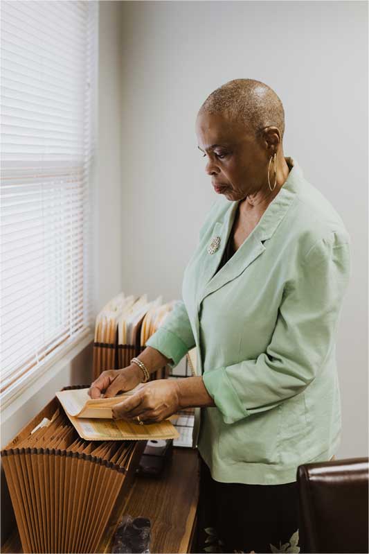 Photo of Joyce A. Williams standing with file folder